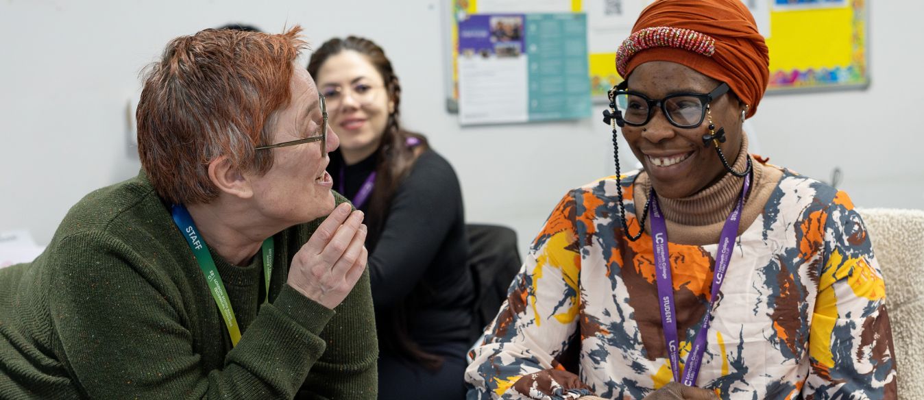 One Lambeth College student and one staff lecturer, posing and smiling to each other