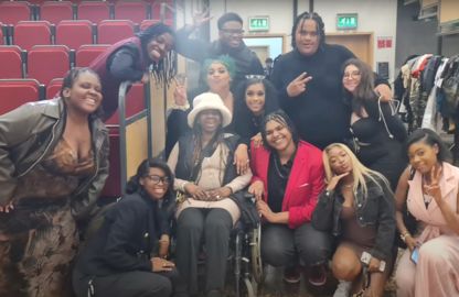 A group of people posing for a photo, including one individual in a wheelchair.
