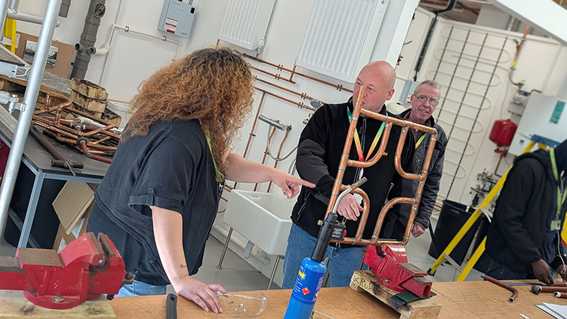 Adults learning plumbing at LSBTC.