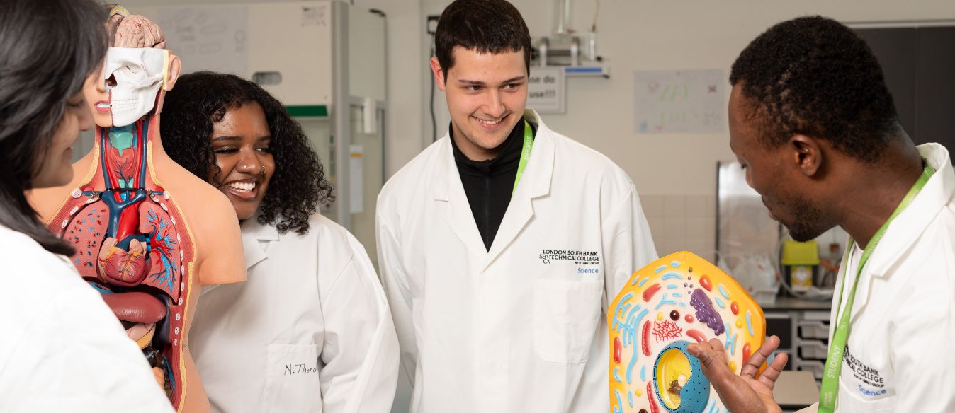 A group of LSBTC science students discussing a model together in a lab setting, engaged and collaborating on their project.
